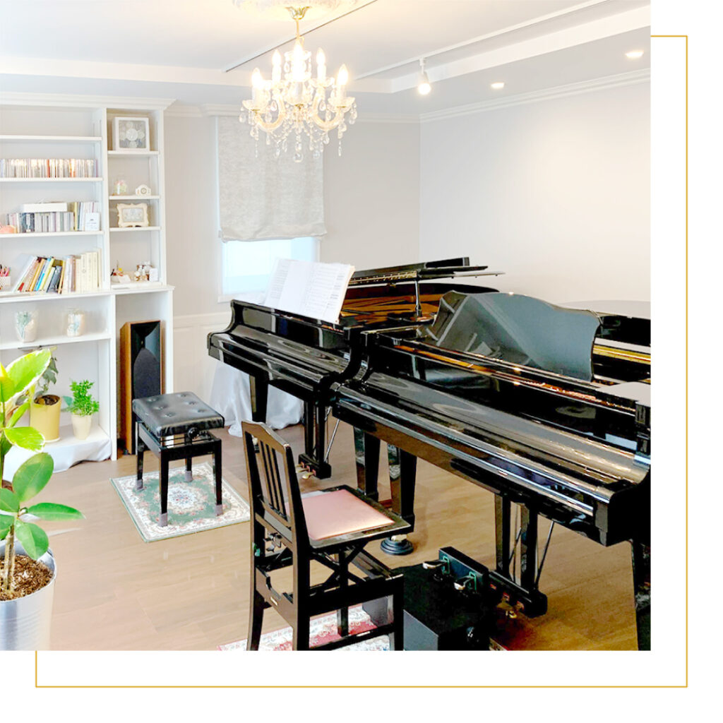 グランドピアノと白を基調とした明るいピアノ教室のレッスン室内装
