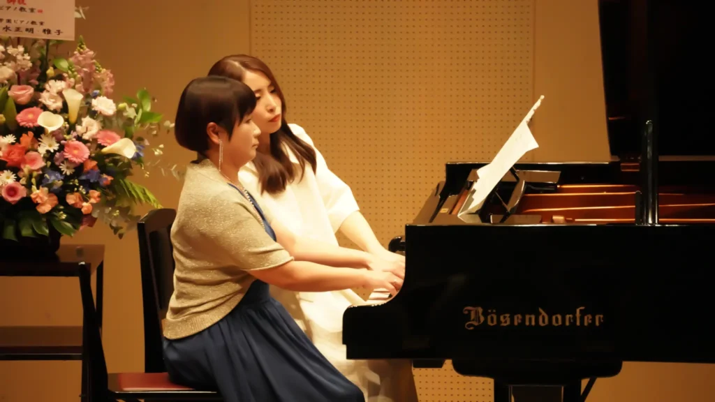 ピアノ発表会でグランドピアノを演奏する生徒